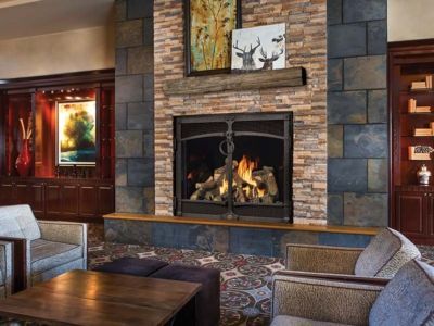 A living room with a fireplace and a couch and chairs