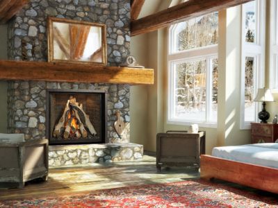 A bedroom with a fireplace and a large window.