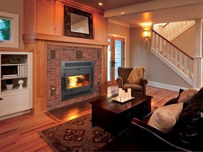 A living room with a fireplace and stairs in the background.