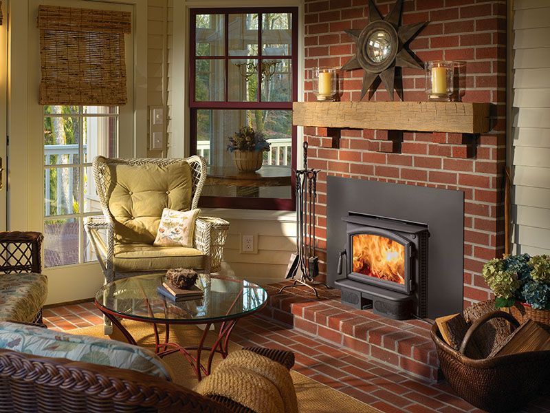 A living room with a brick fireplace and a wood stove.