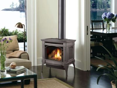 A gas fireplace is sitting in a living room next to a window.
