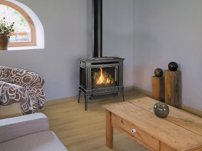 A living room with a wood stove and a wooden table.