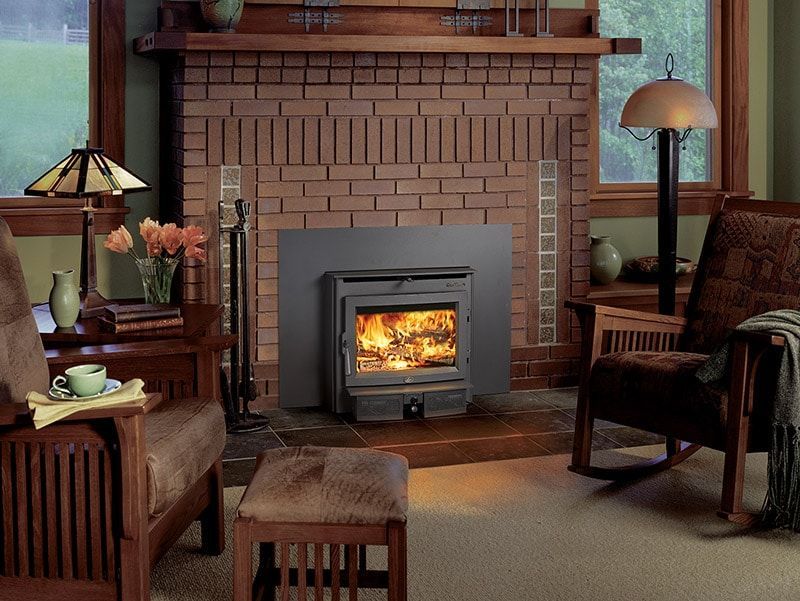 A living room with a brick fireplace and a wood stove