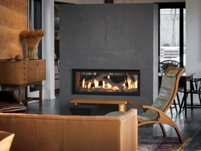 A living room with a fireplace , couch , chair and table.