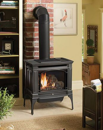 A black stove is sitting in a living room next to a brick wall.