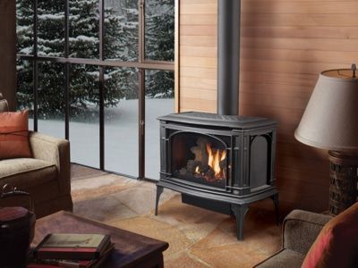 A living room with a wood stove and a large window.