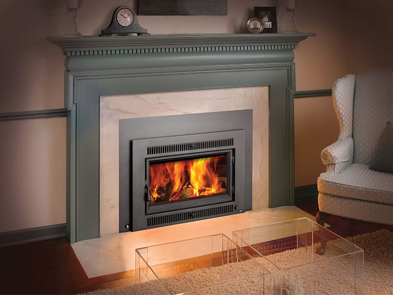 A living room with a fireplace and a clock on the mantle.