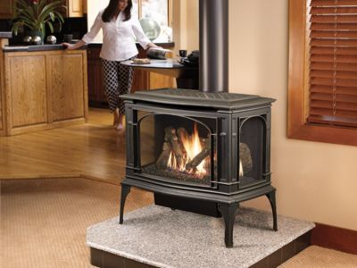 A woman is standing in front of a gas stove