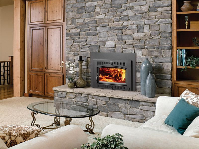 A living room with a fireplace and a stone wall