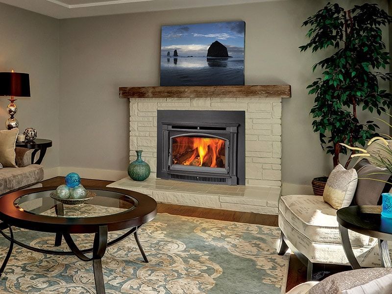 A living room with a fireplace and a painting on the wall.