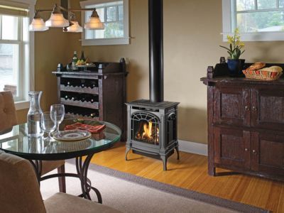 A dining room with a table and chairs and a wood stove
