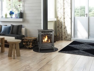 A living room with a wood stove and a couch.