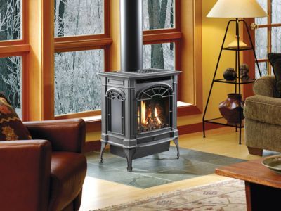 A living room with a stove in the middle of it