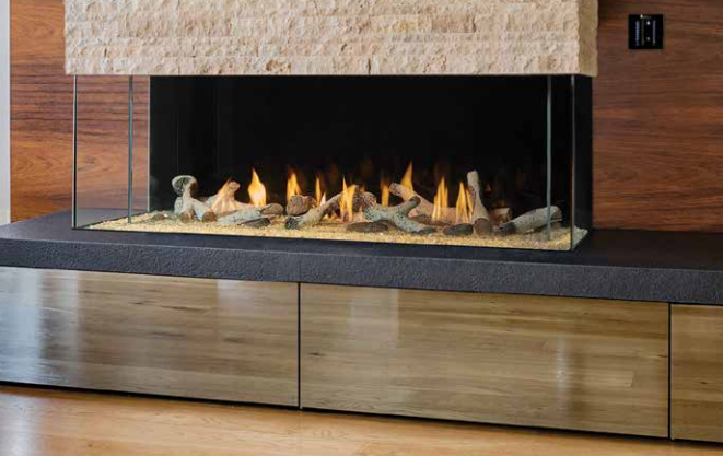 A fireplace is sitting on top of a wooden shelf in a living room.