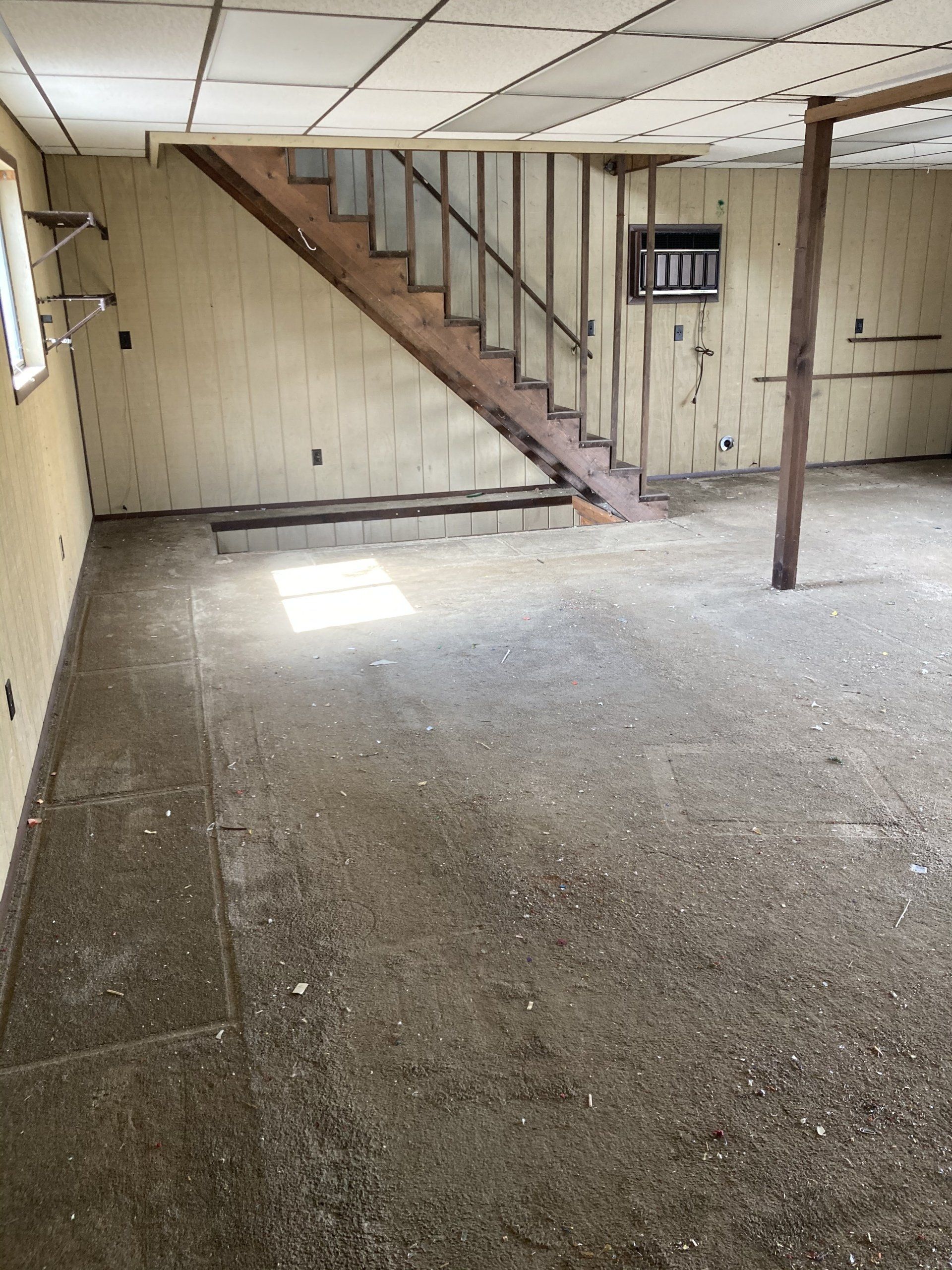 An empty basement with stairs leading up to the second floor