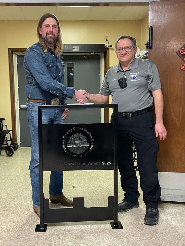 two men shaking hands behind a podium