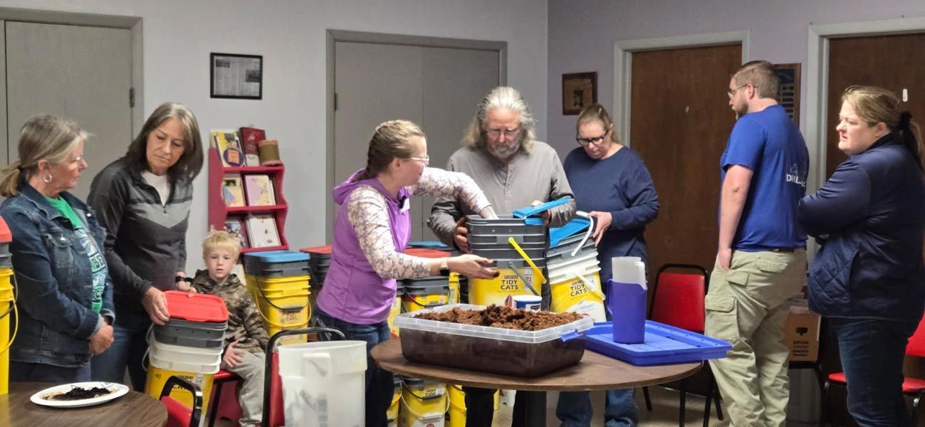 man and woman working with dirt/soil in a classroom setting