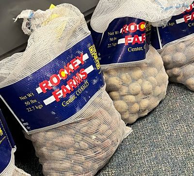 50 lb mesh bag of potatoes with a red and blue label
