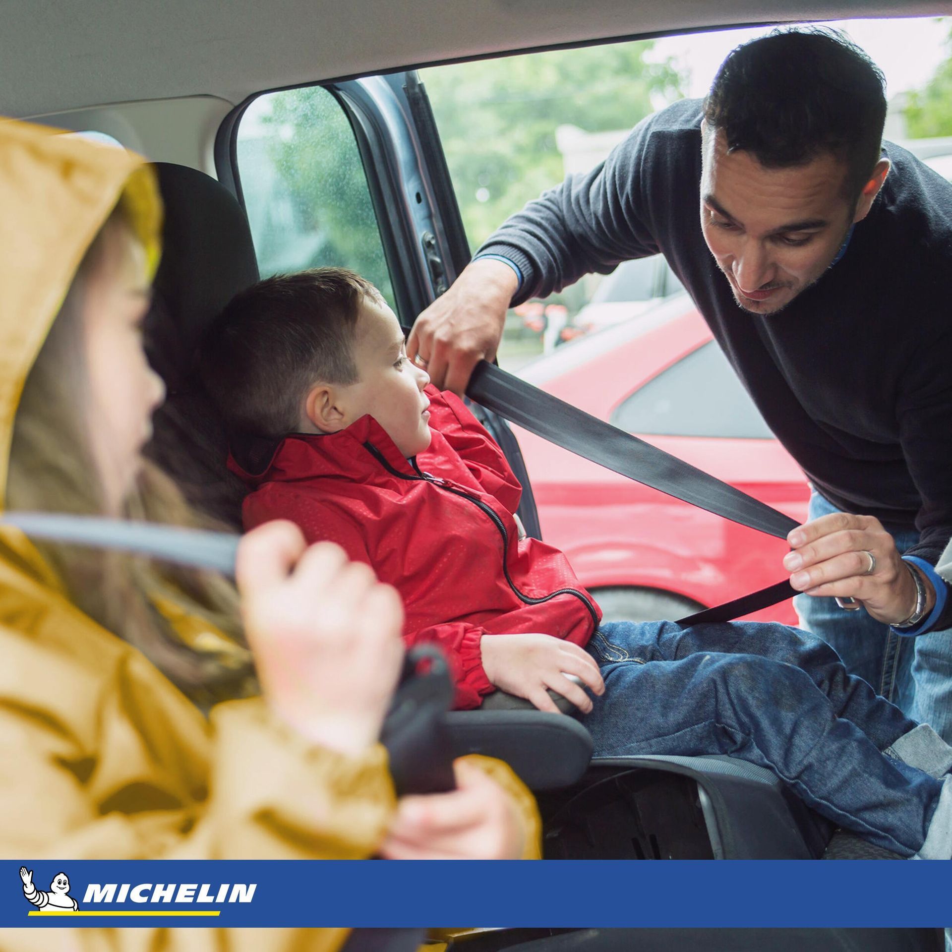 a man is putting a child in a car seat