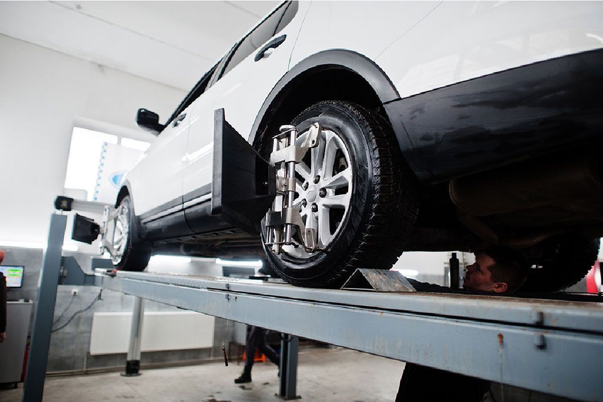 a car is being adjusted on a lift in a garage