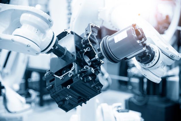 Robotic arms assembling a mechanical component in a bright factory setting Robotic arms assembling a mechanical component in a bright factory setting