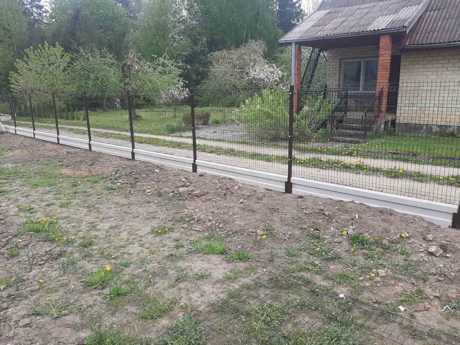 Tvora juosia žole apaugusį lauką priešais namą.