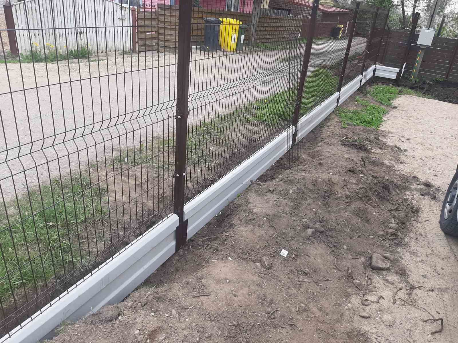 Šalia gruntinio kelio statoma tvora.