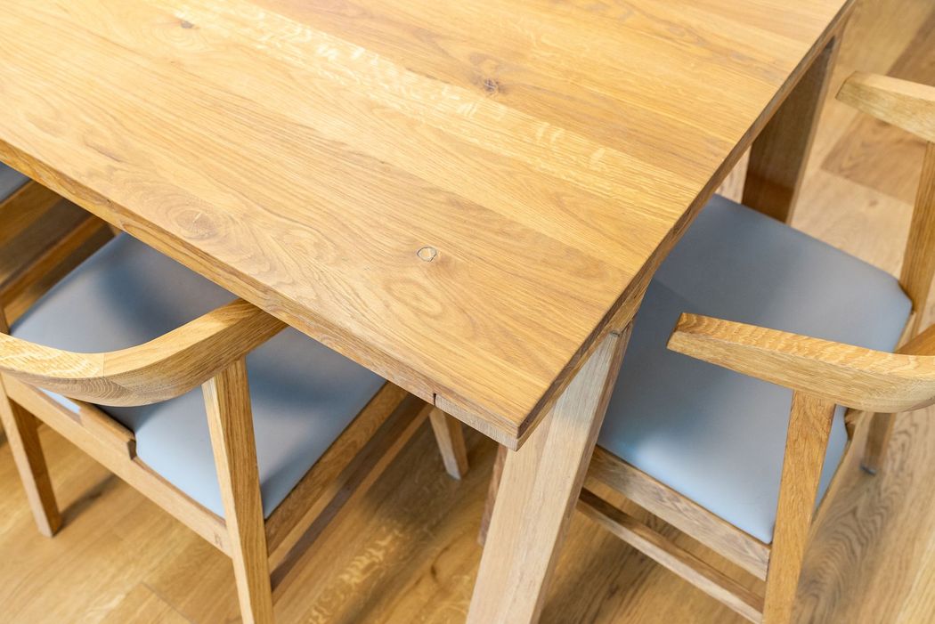 Tavolo in legno con sedie abbinate e cuscini azzurri in una zona pranzo