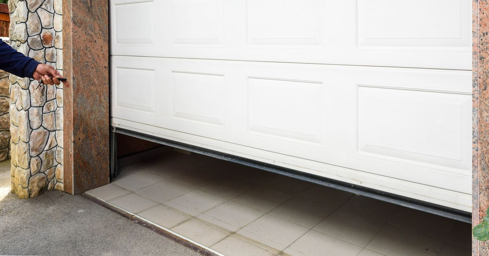 Garage door partially open, operated by a person holding a remote in Lumberton, NC.