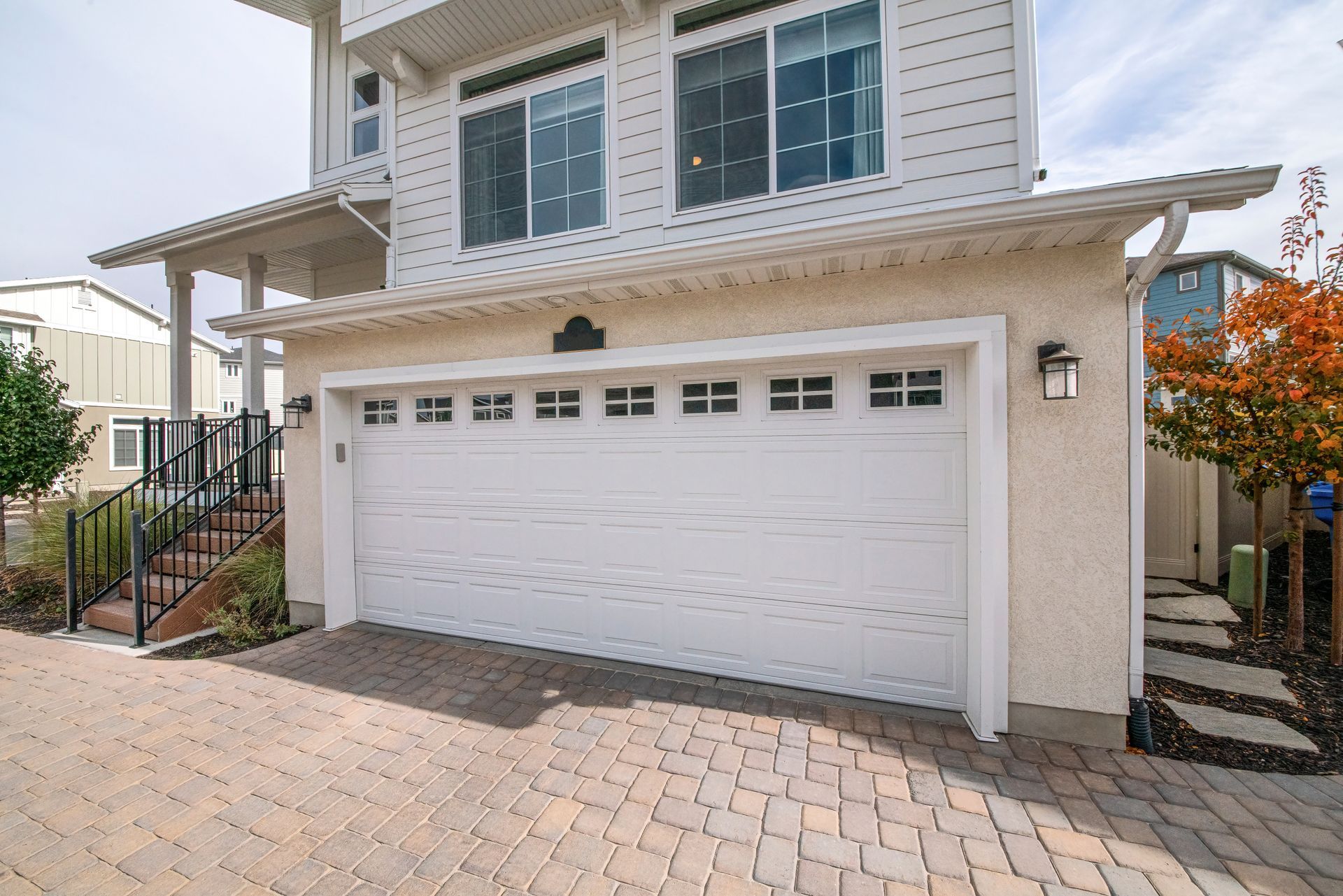 a large white house with a large white garage door .