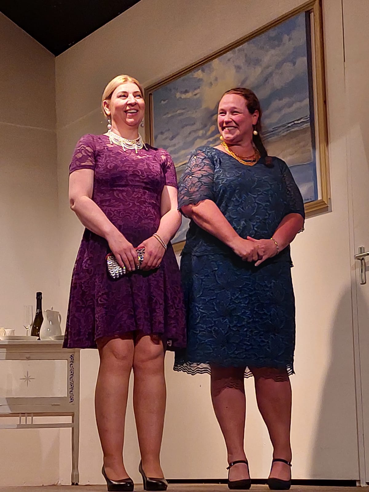 De tante van Charlie. Eline en Celine in avondjurken staan ​​glimlachend op een podium.