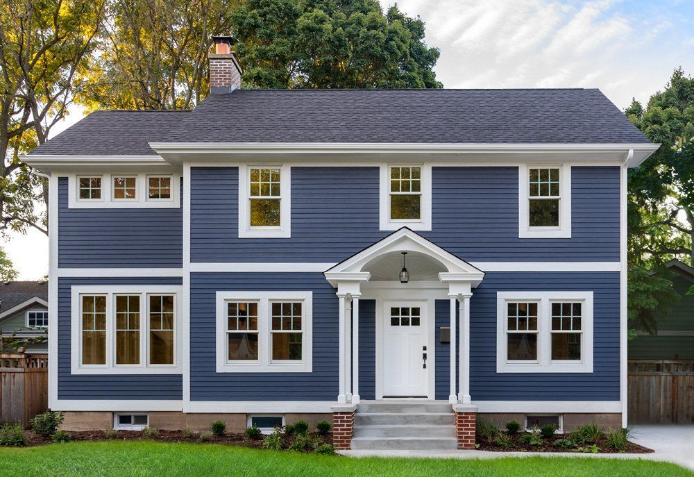 A large blue house with white trim and windows