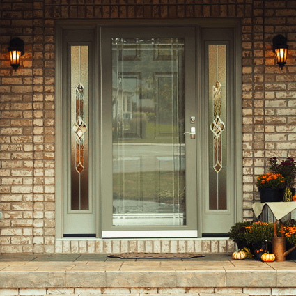 The front door of a brick house has a stained glass window