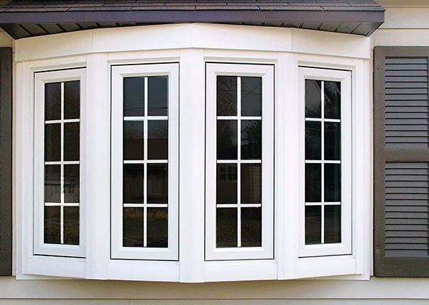 A bay window with shutters on the side of a house