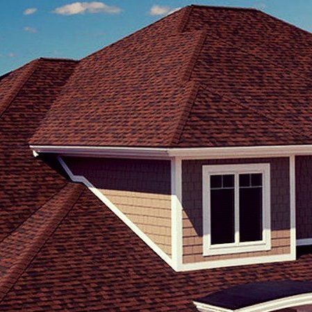 A house with a red roof and a window on the roof.