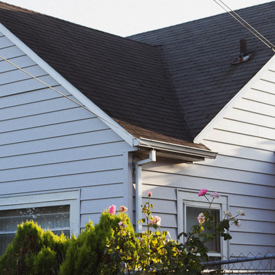 A house with a black roof and a white siding