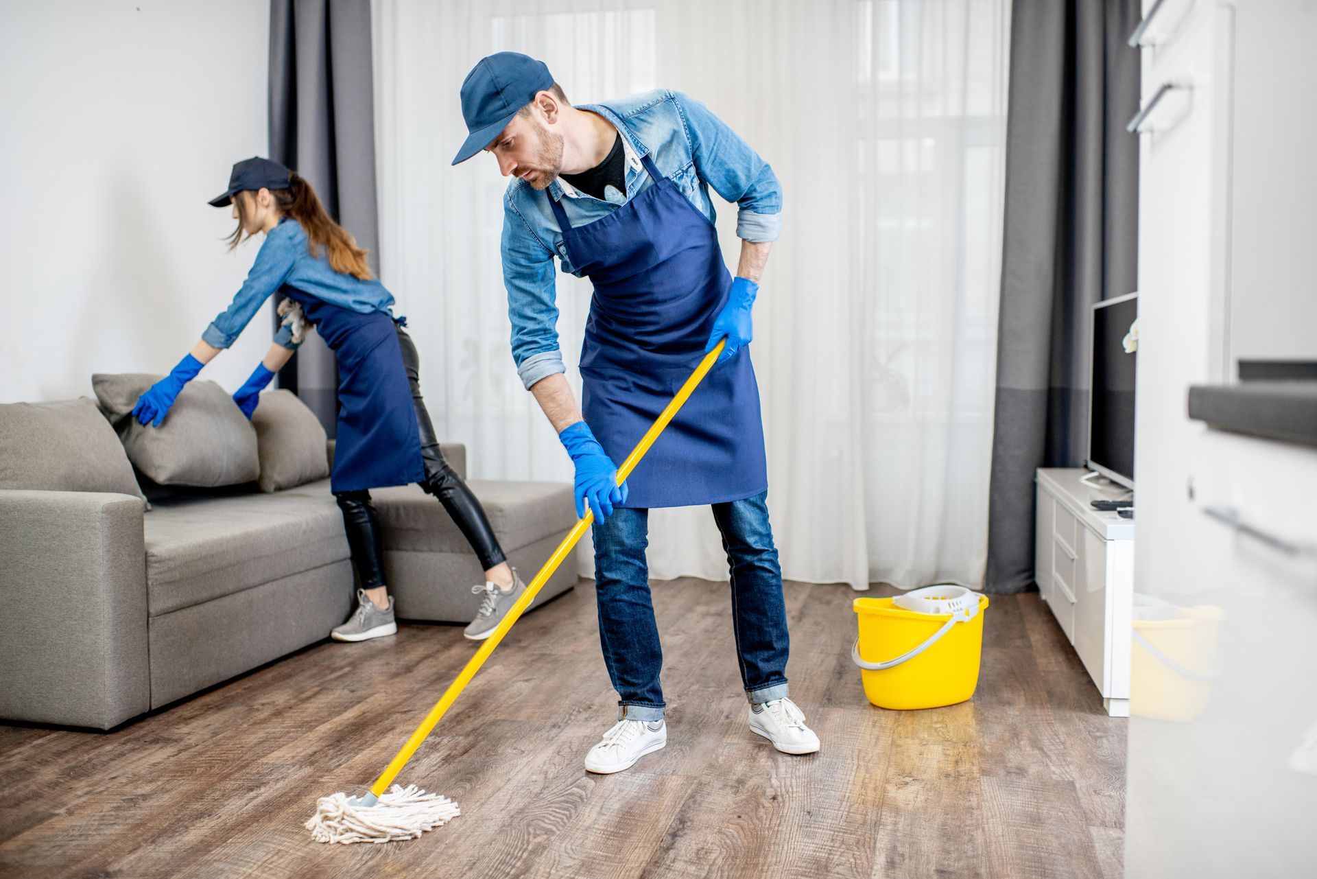 A team of cleaners is cleaning a living room.