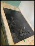 A dirty stove top oven is sitting on top of a counter.