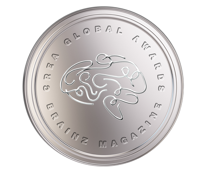 Silver round medallion with embossed abstract line design and circular lettering around the edge