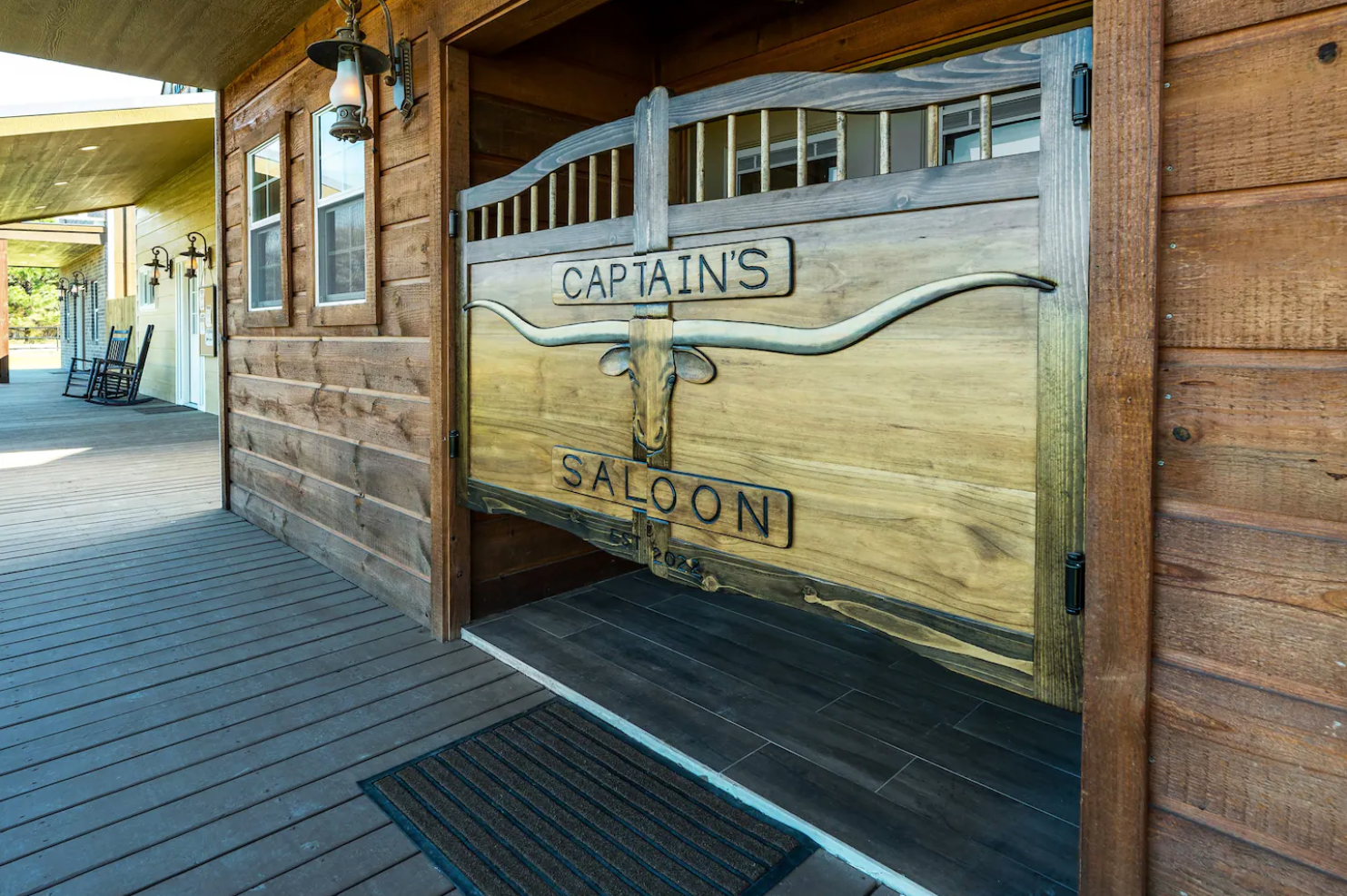 Wooden saloon doors with a longhorn steer skull emblem and