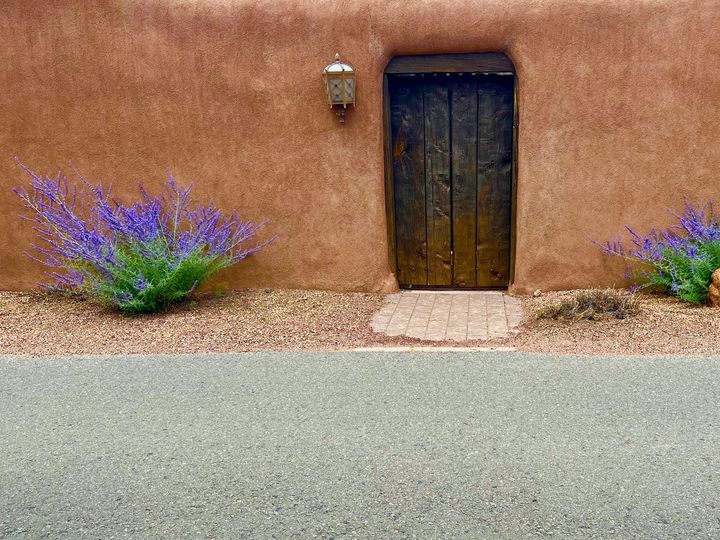 Concrete pathway in front of adobe New Mexico home.