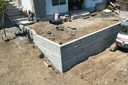 Job site shows a retaining wall being built.