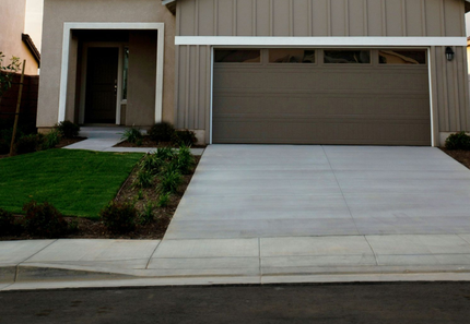 Concrete driveway that connects to a main sidewalk and walkway to the front door
