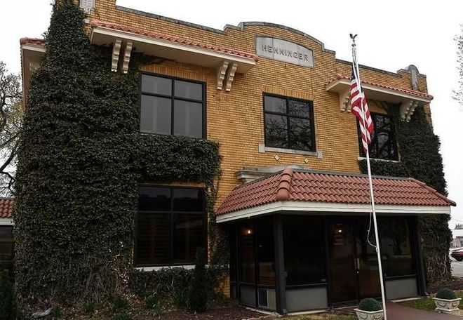 Brick building with ivy, red-tiled awnings, and an American flag out front