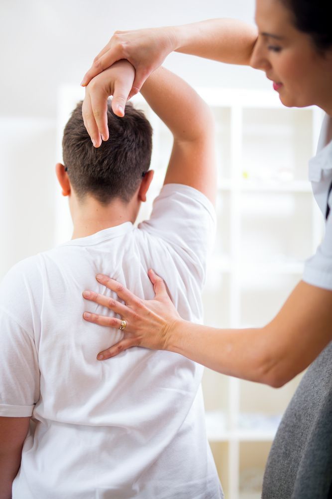 A Woman Is Giving A Man A Massage On His Back — Back In Motion Chiropractic & Healthcare In Babinda, QLD