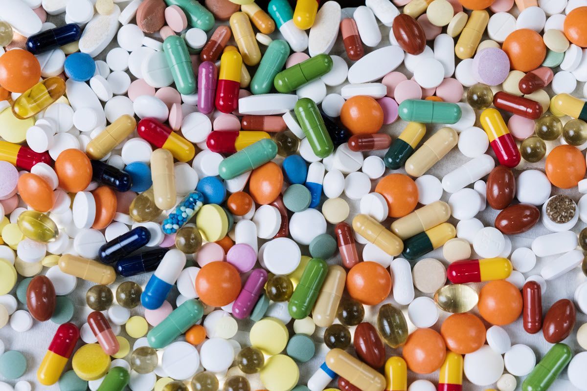 Assorted colorful pills and capsules scattered together in a close-up view
