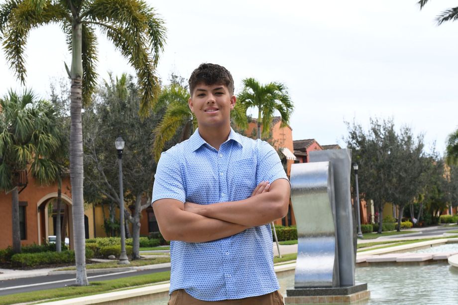 Preston, founder of Zyra Web, standing confidently near a fountain in a palm-lined courtyard