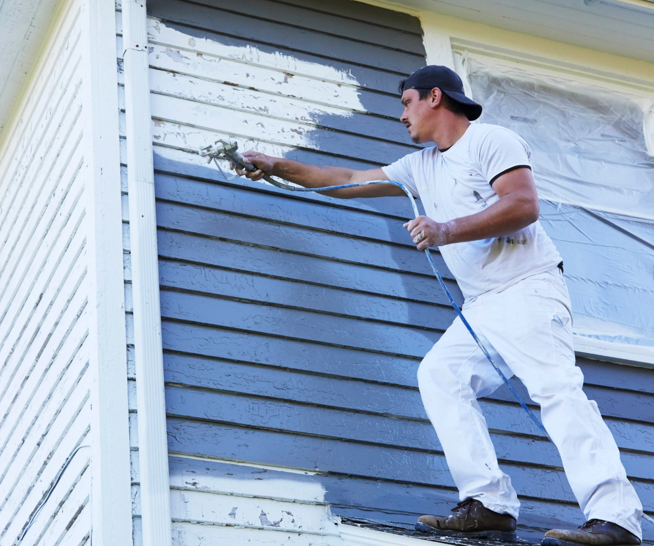 A Man painting the exterior of a house in Watertown, MA