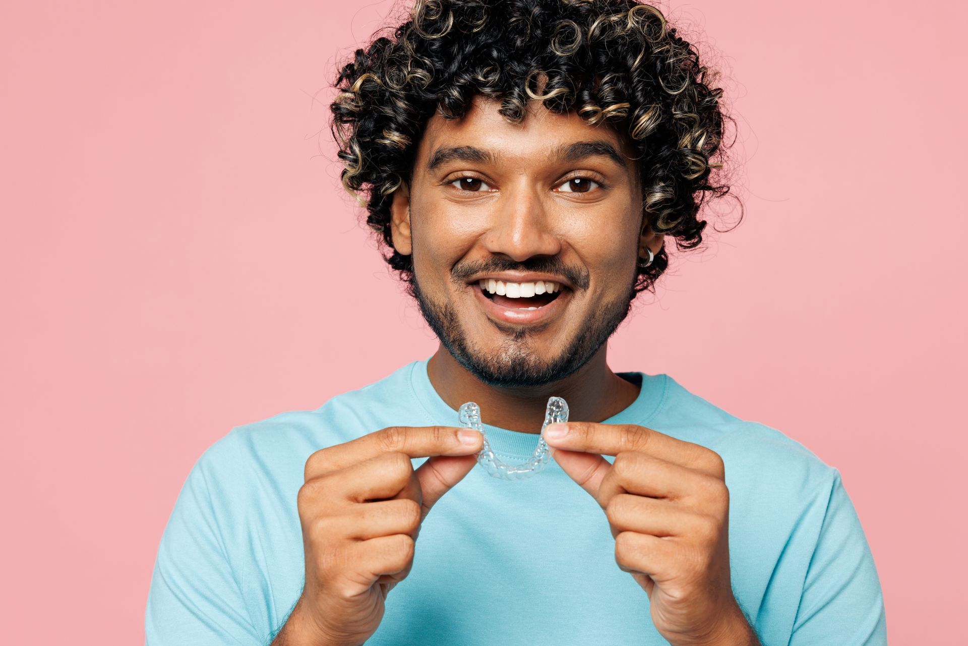 Dentist tightening braces on a smiling patient’s teeth