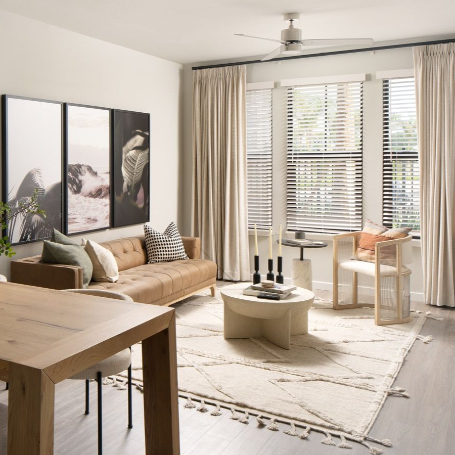 Living room with a wooden dining table, bench, and chairs, and a brown leather sofa.